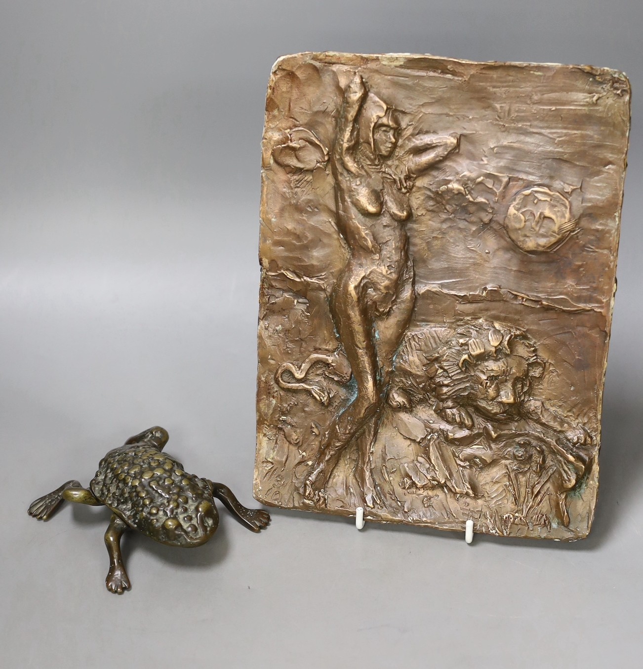A bronze abstract wall panel depicting a female amongst a lion, 24.5 x 18.5cm, together with a vessel in the form of a toad (2)